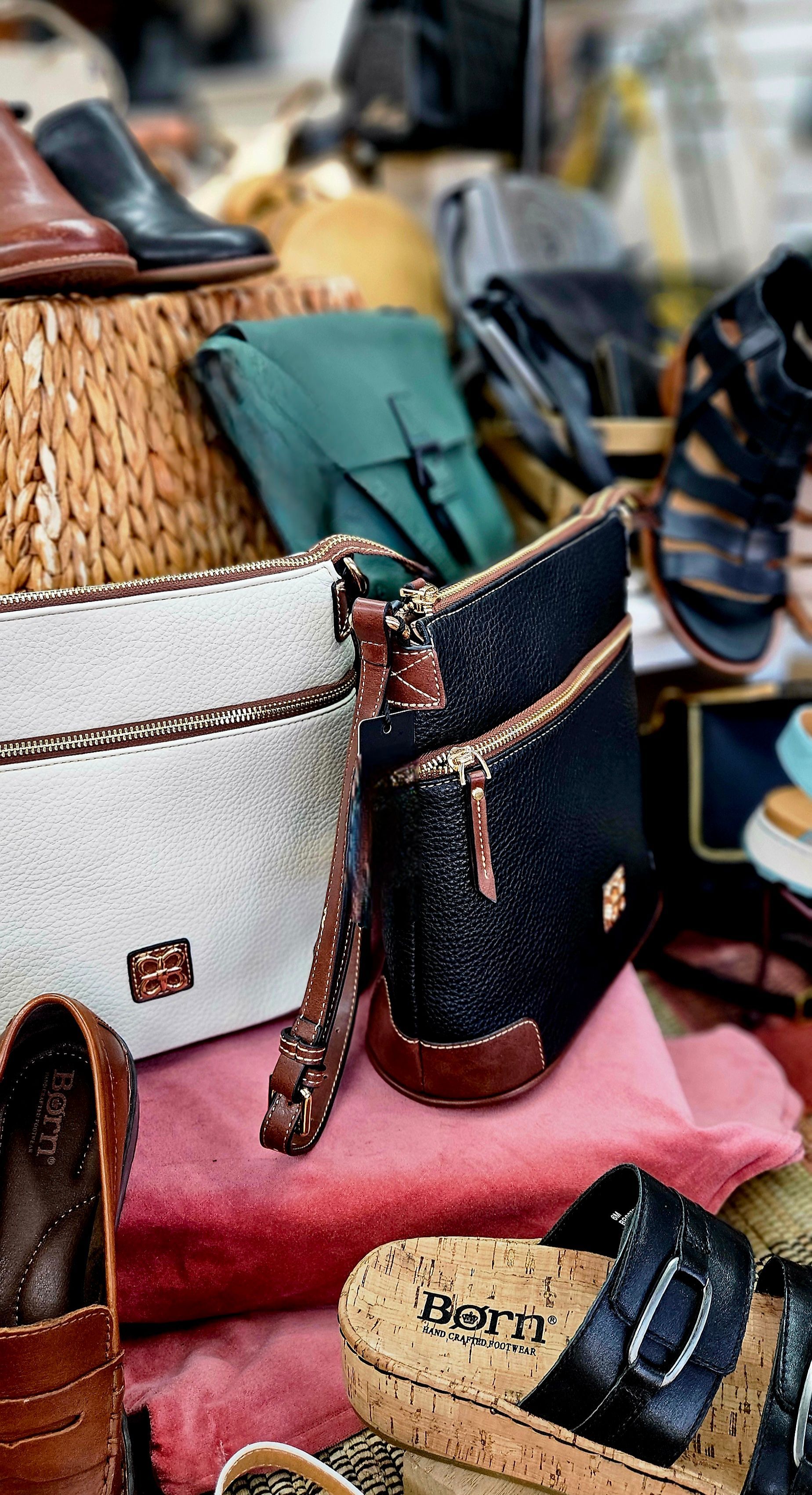 A white purse with blue flowers on it is hanging on a rack