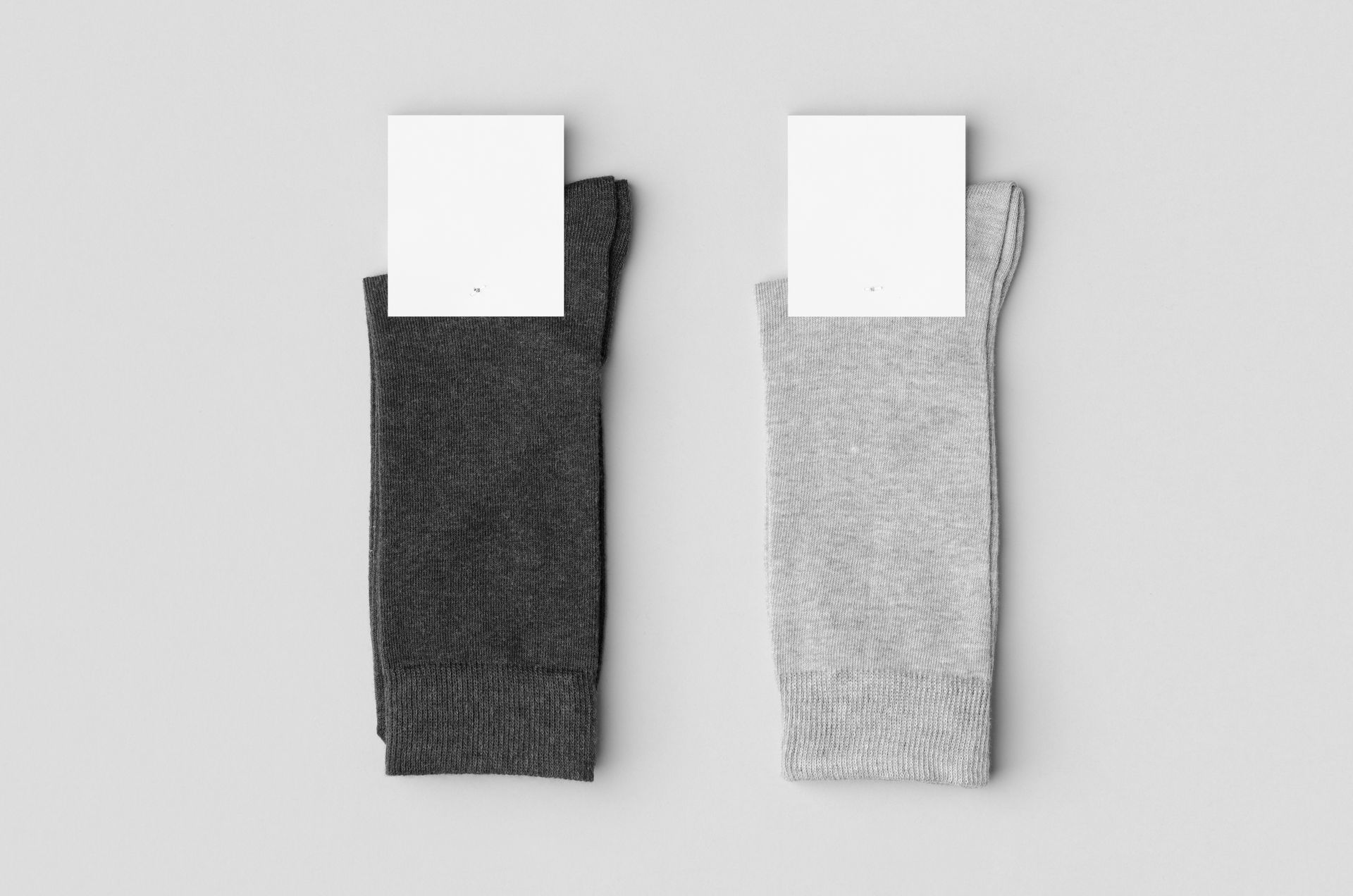 Two pairs of socks with labels on them on a white background.