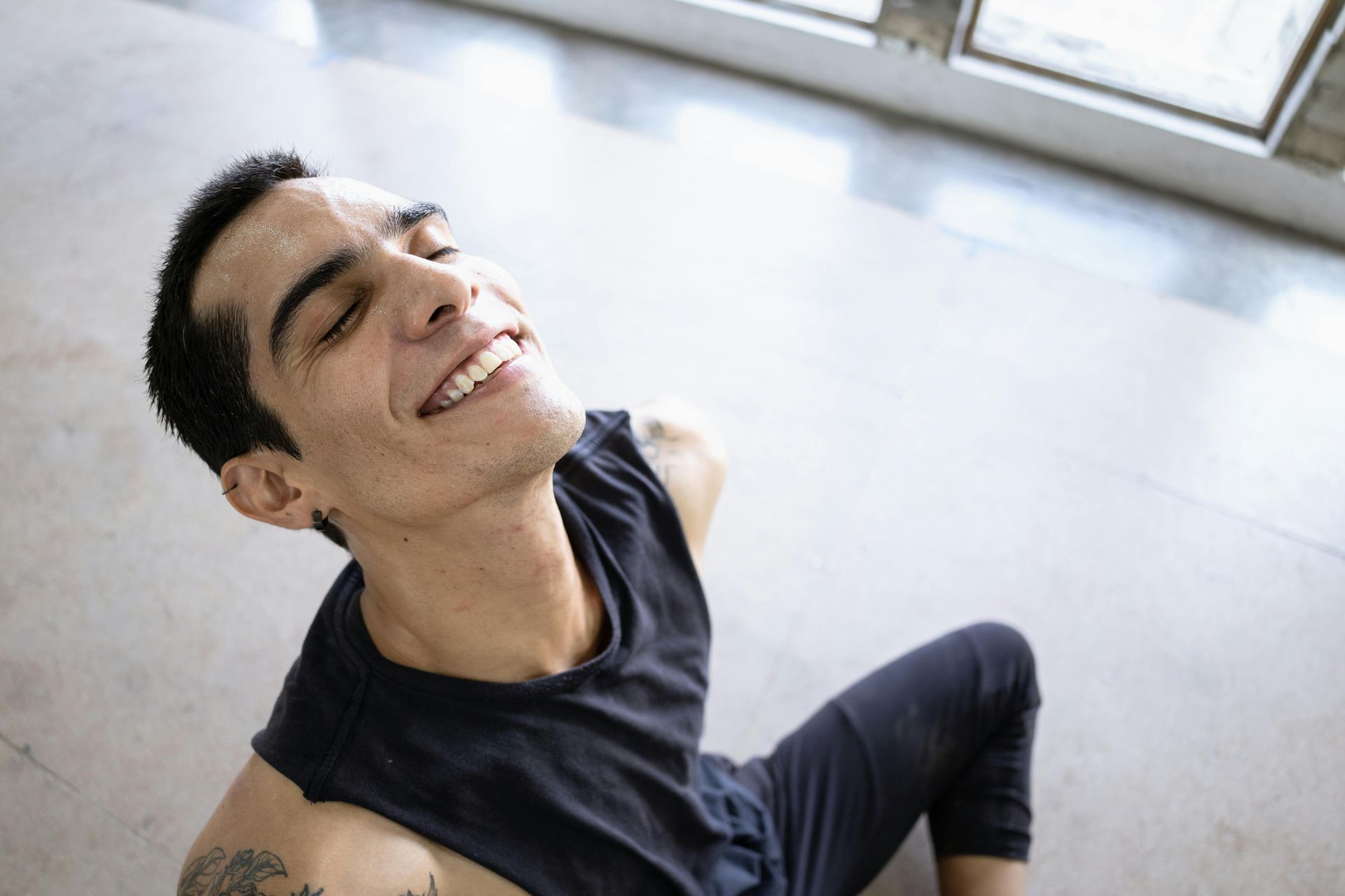 Relaxed man in workout clothes enjoying post-yoga endorphins in fitness studio