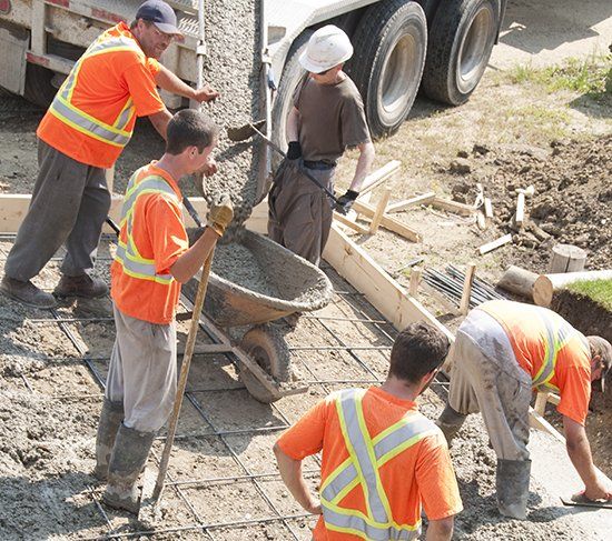 Footing Contractors — Construction Workers Pouring Cement in Cleves, OH