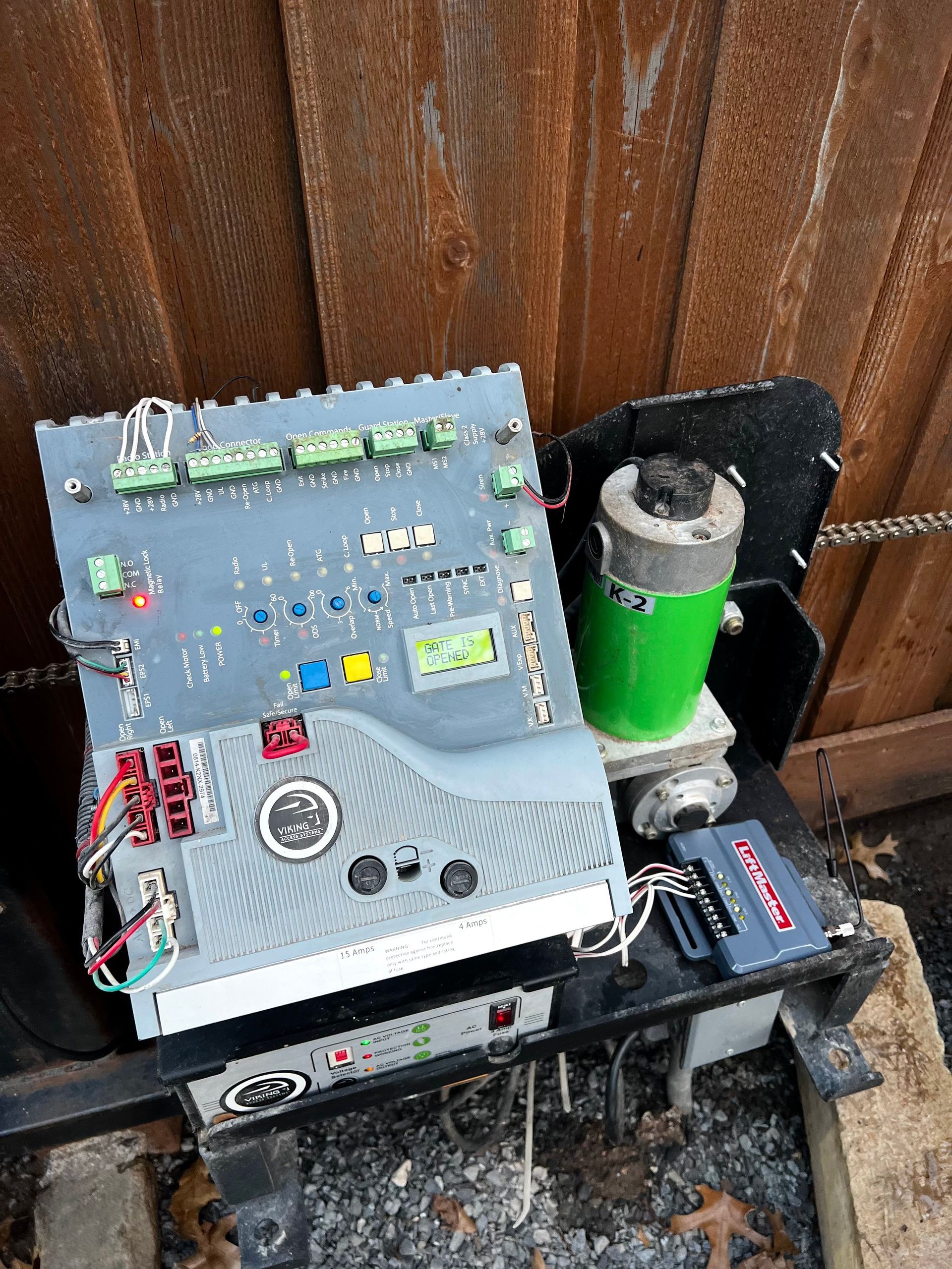 A machine is sitting on a table next to a wooden fence.
