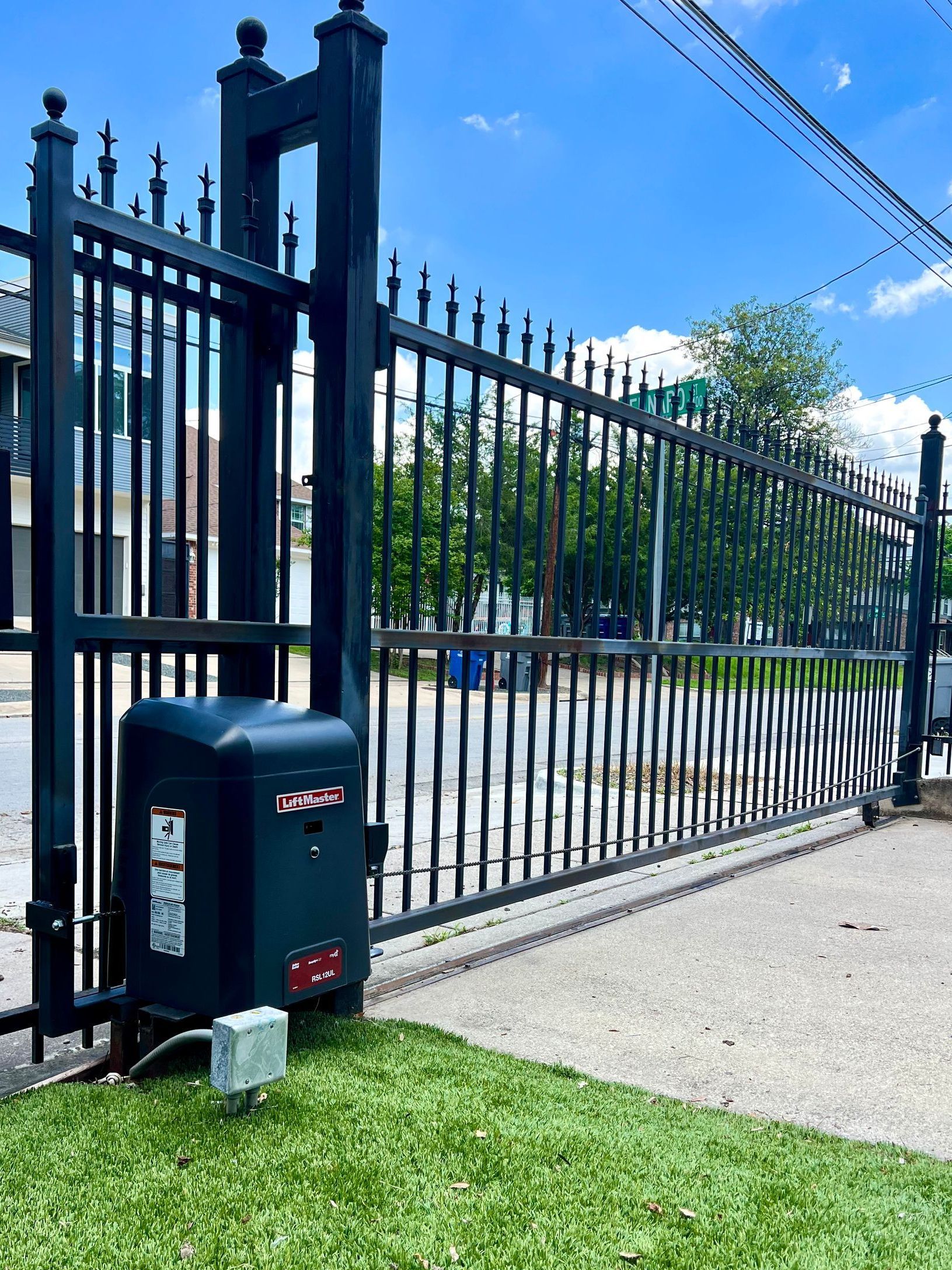 A black sliding gate with a motor attached to it