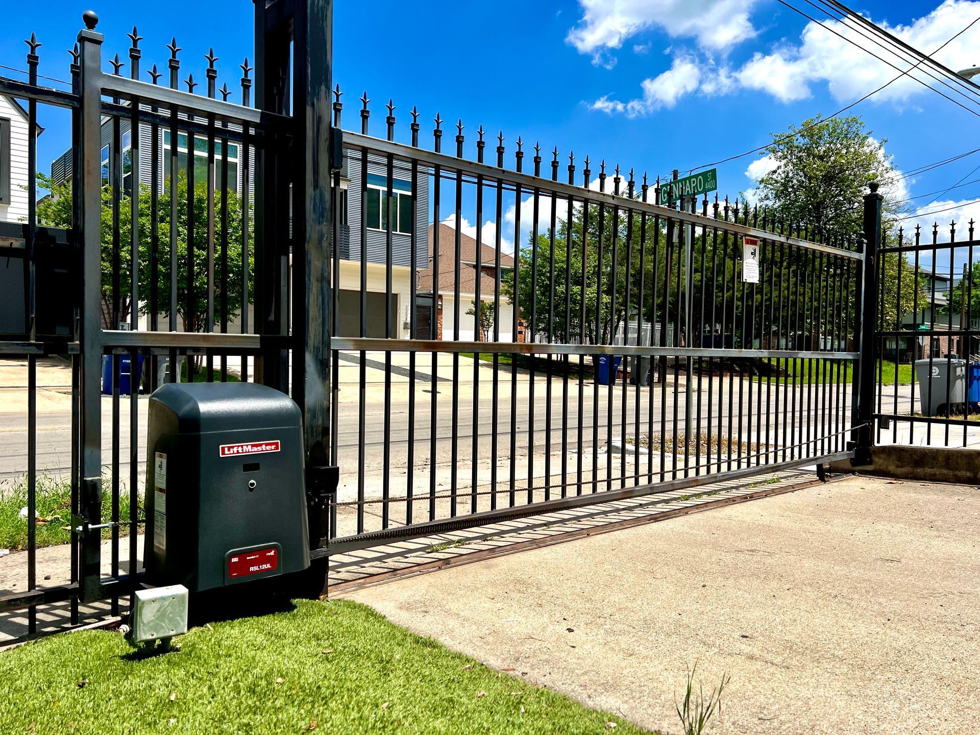 A sliding gate with a mailbox in front of it.