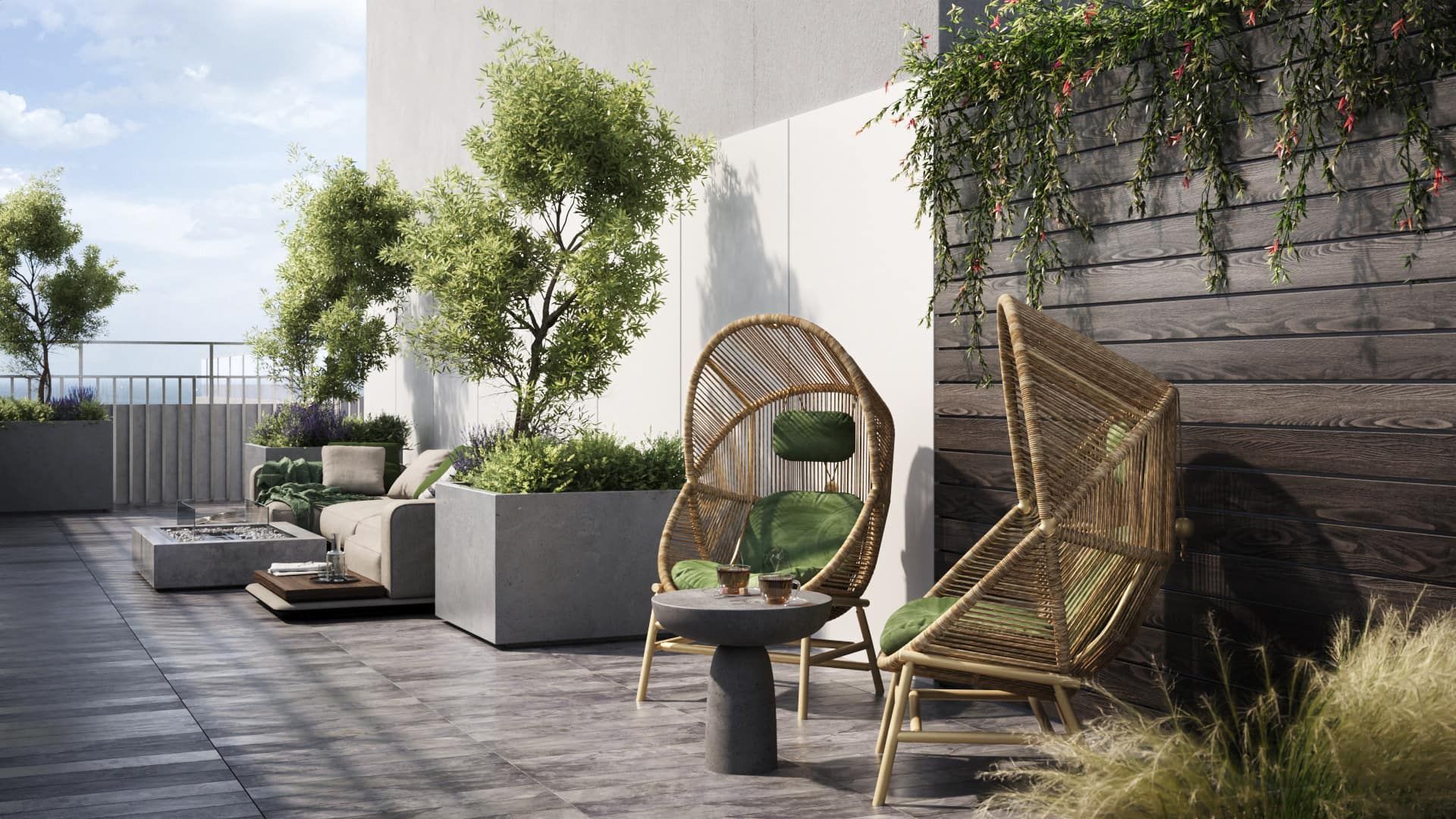 Rooftop patio with woven chairs, trees, and plants against a white and grey wall.