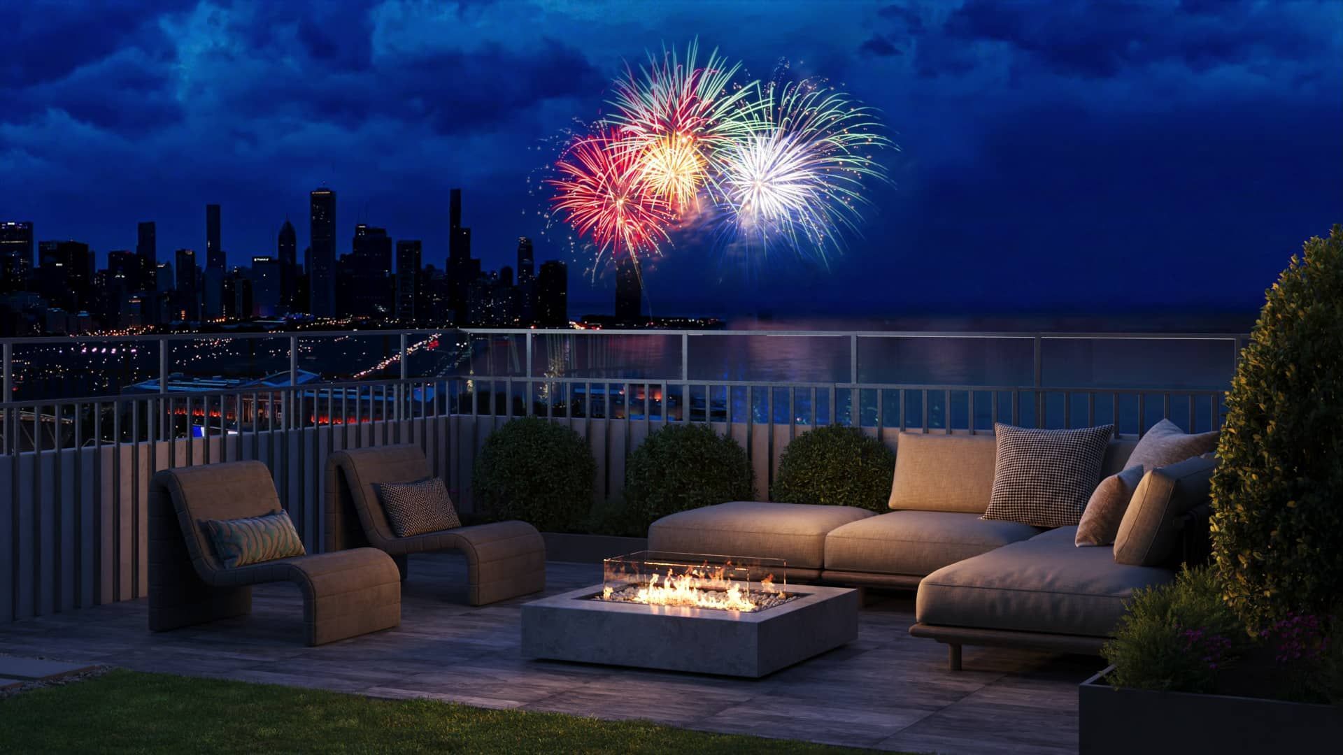 Rooftop patio with city view at night, fireworks overhead. Relaxing furniture, fire pit, and skyline.