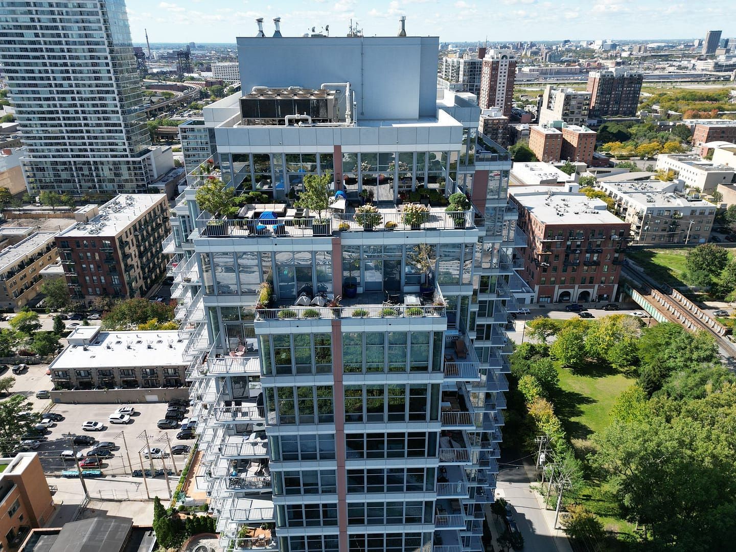High-rise building with balconies and rooftop gardens, downtown setting.