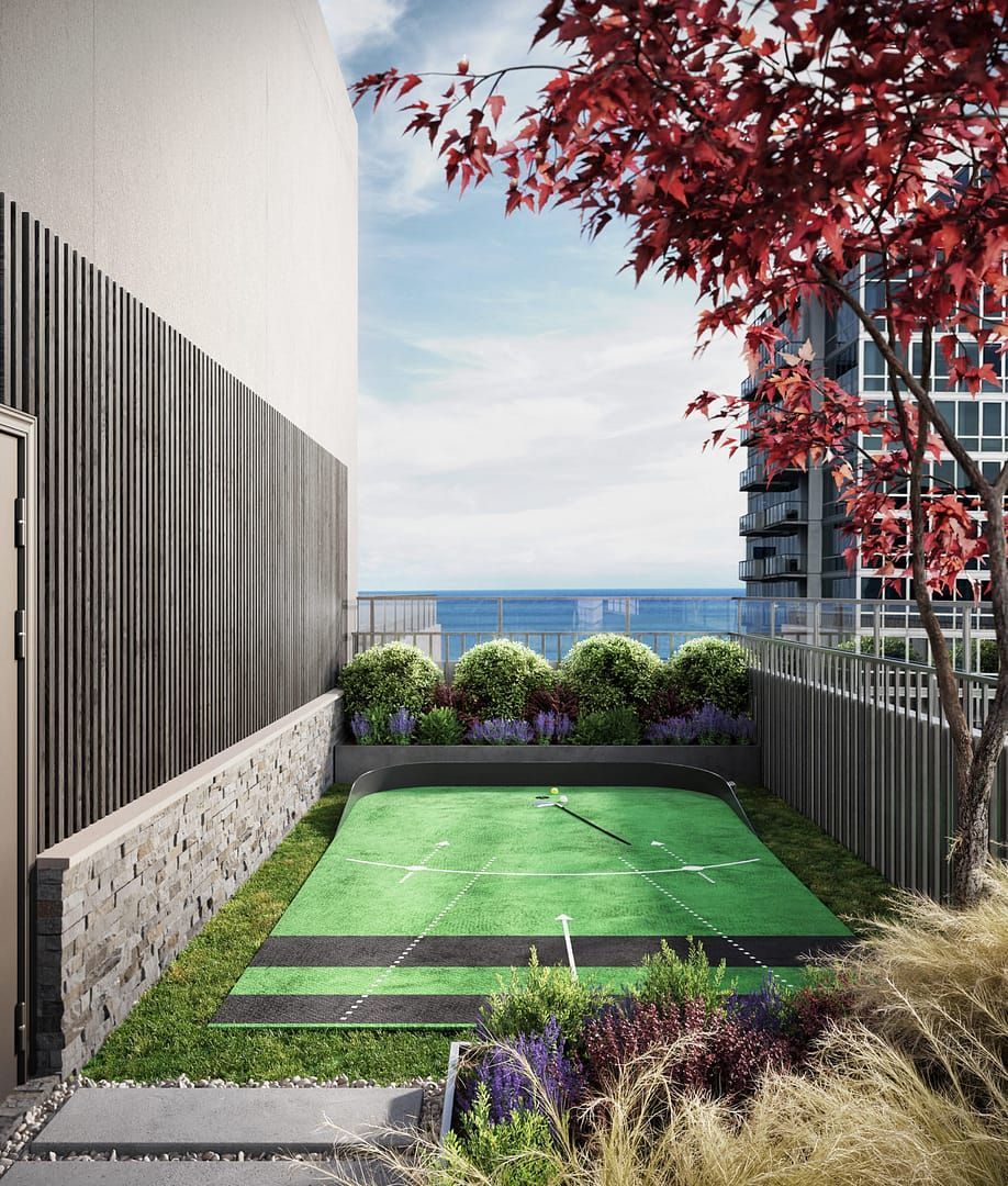 Rooftop putting green surrounded by landscaping. Red tree and ocean view in the distance.