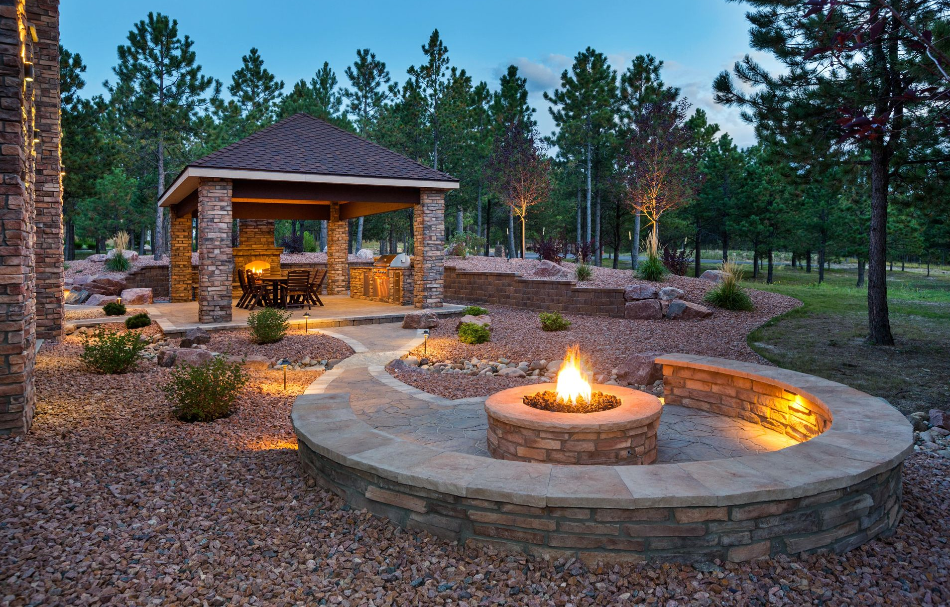 Outdoor patio with fire pit and stone gazebo.