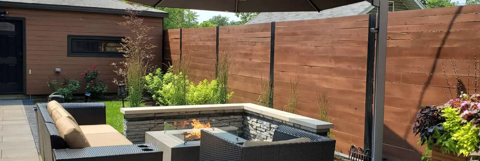 Outdoor patio with fire pit and wood fence, creating a cozy backyard space.