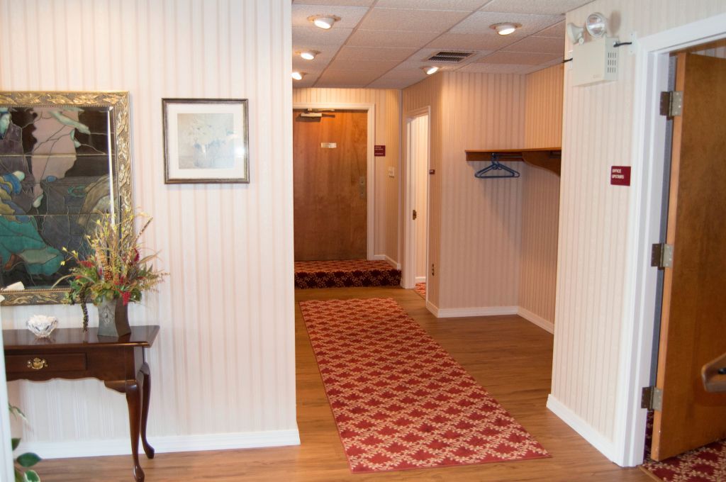 Hallway with red patterned runner rug, wood doors, and decorative table.