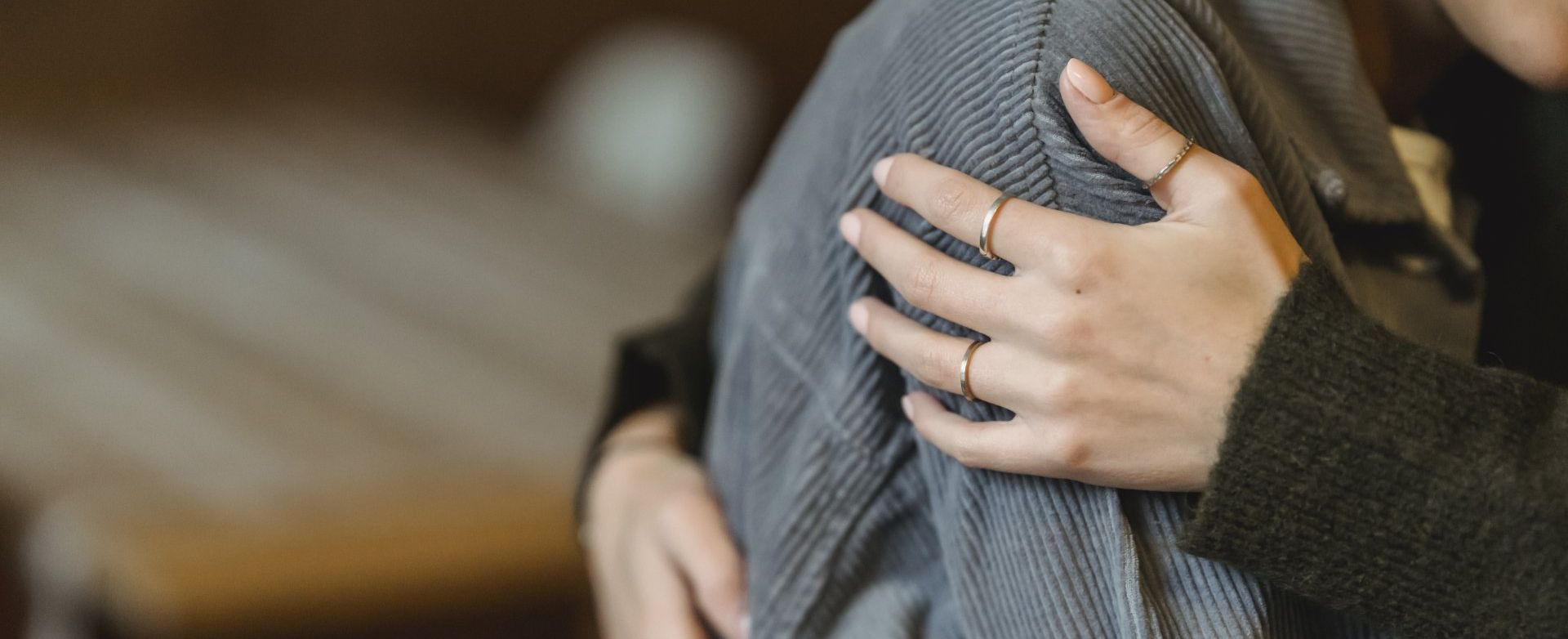 a woman wearing rings on her fingers hugging friend