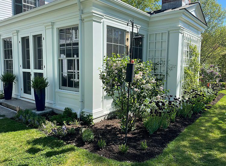 A white house with a lush green lawn in front of it.