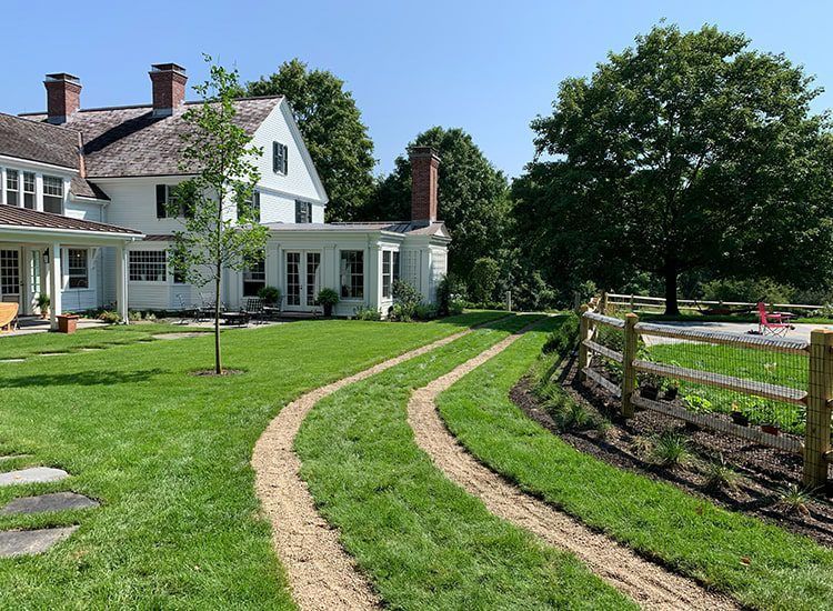 A large white house with a dirt path leading to it