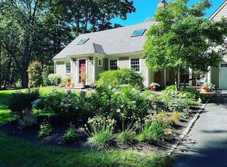 A house with a lot of plants in front of it