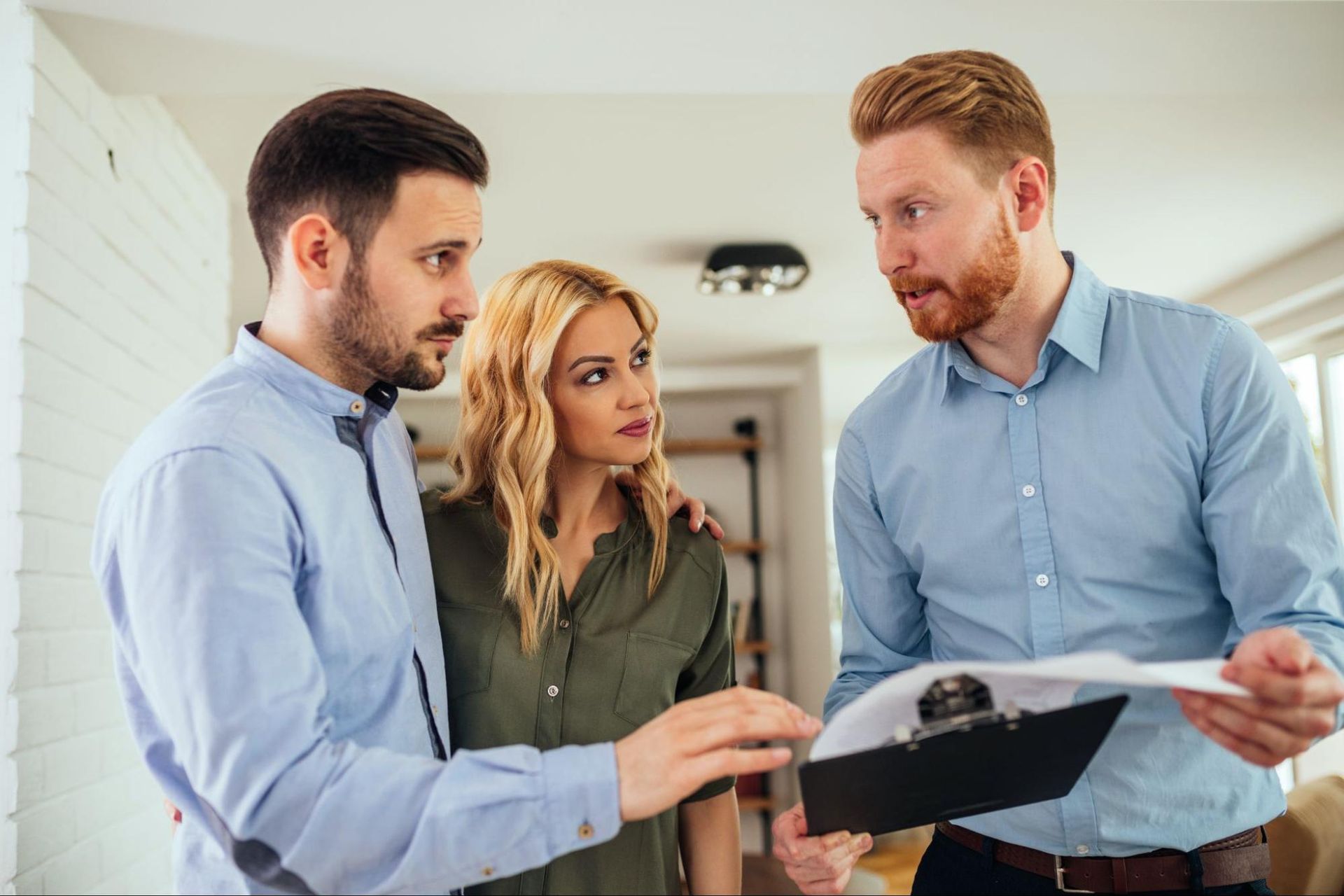 Home inspector reviewing findings with a homeowner using a clipboard during the inspection walkthrough.