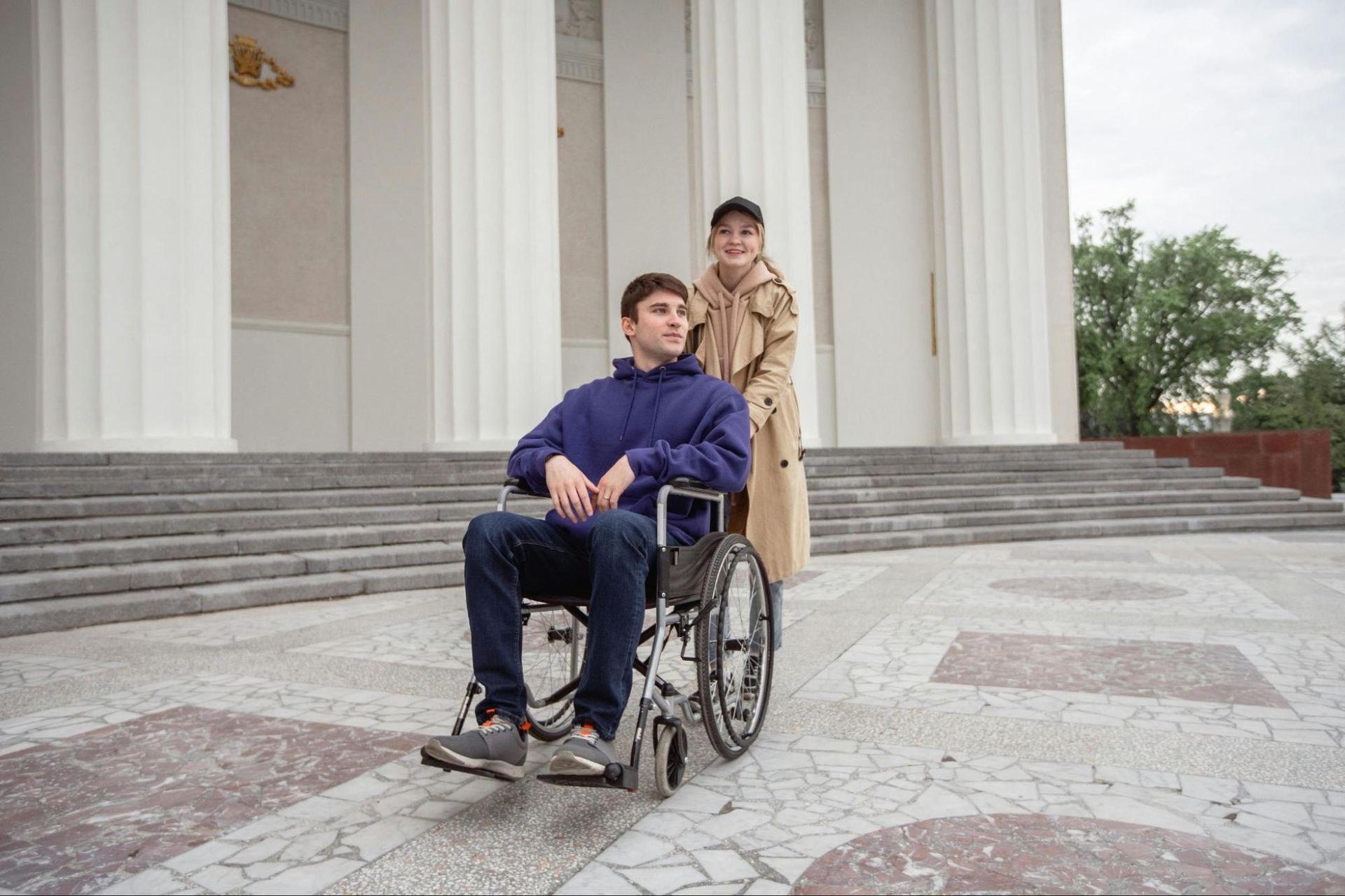 man on wheelchair being assisted