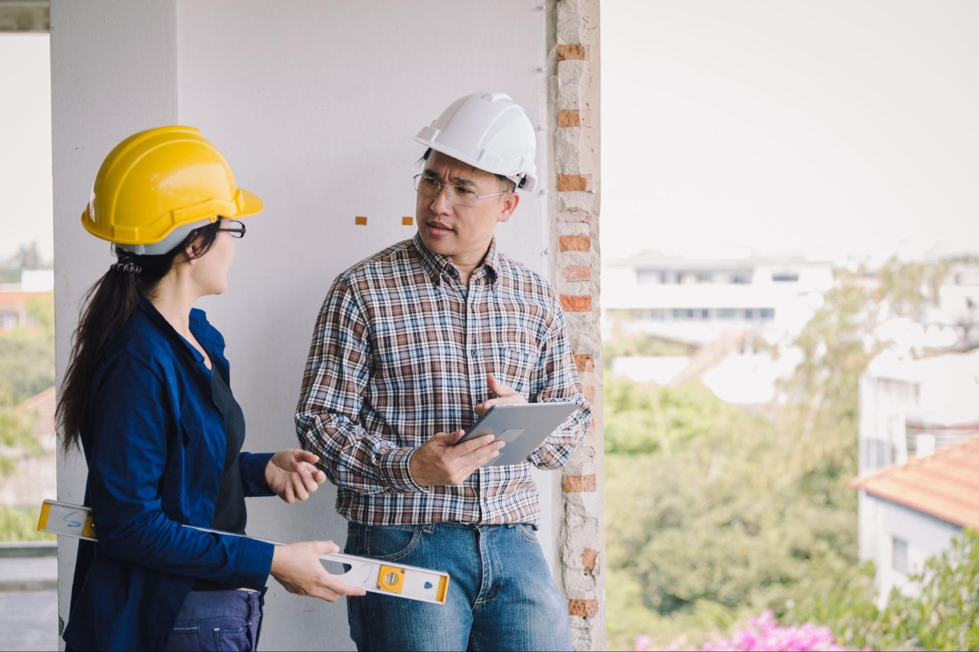 two people in hard hats, talking, representing property service companies
