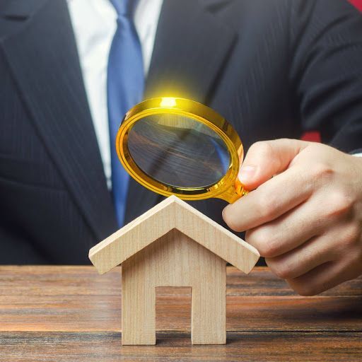Home inspector examining model house with magnifying glass for home inspection League City services.