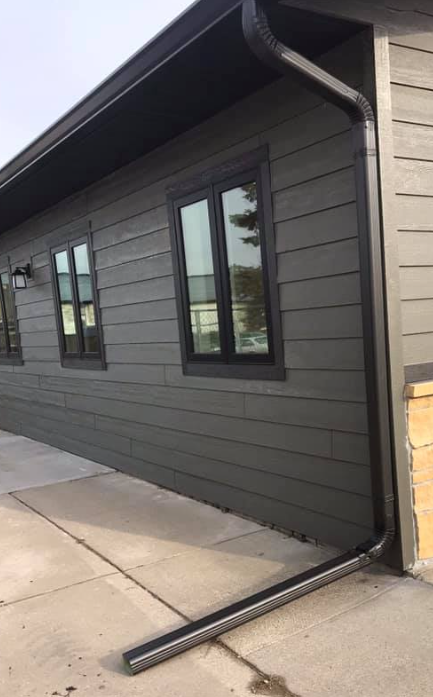 Dark gray building with matching gutters and black window frames.