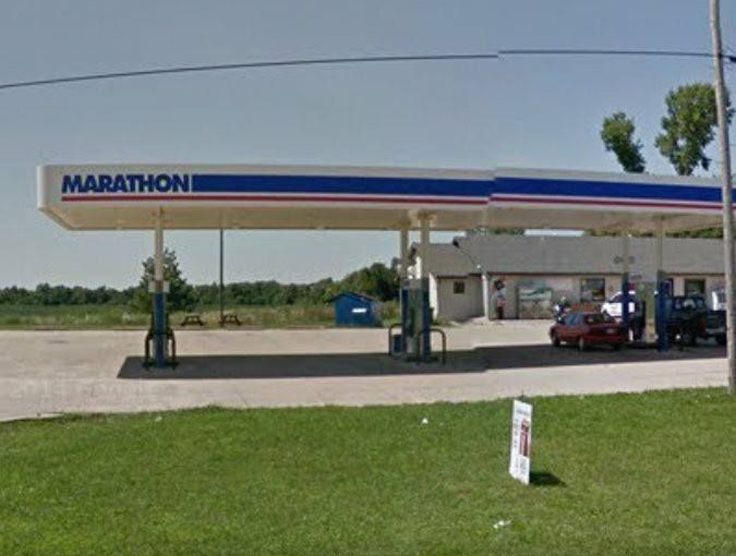 Marathon gas station with blue and red canopy, small building, and cars at pumps.