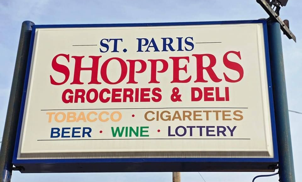 Sign for St. Paris Shoppers: groceries, deli, tobacco, cigarettes, beer, wine, and lottery.