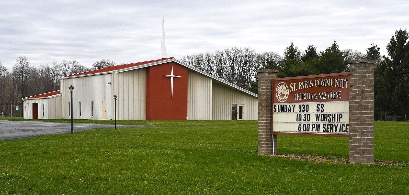 Church building with red cross, sign reads Sunday School, 10:30 Worship.