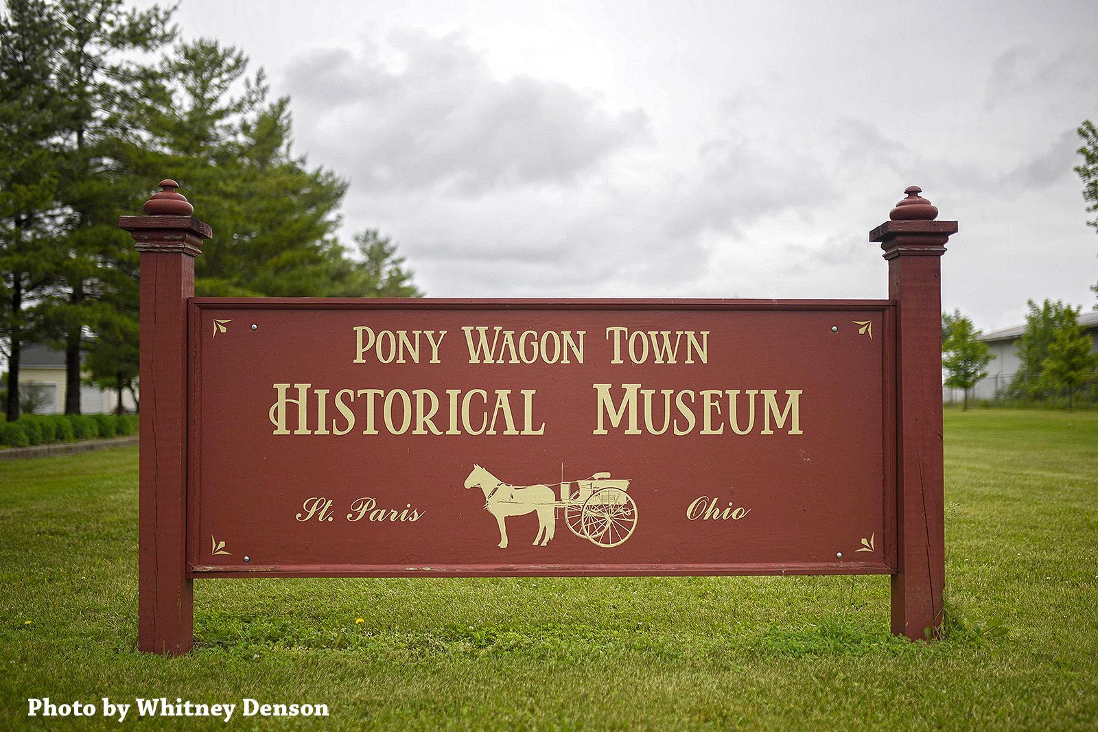 Sign for Pony Wagon Town Historical Museum in Ohio. Brown with gold lettering, logo of a horse and wagon.