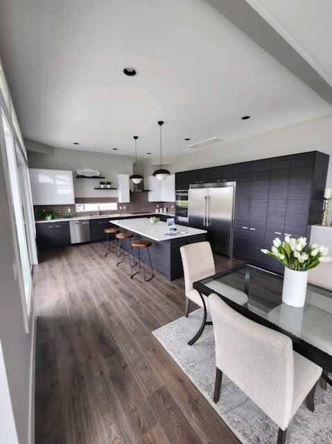A kitchen with a table and chairs and a vase of flowers