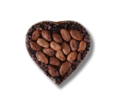 A heart shaped bowl filled with raw cocoa beans