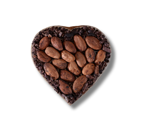 A heart shaped bowl filled with raw cocoa beans