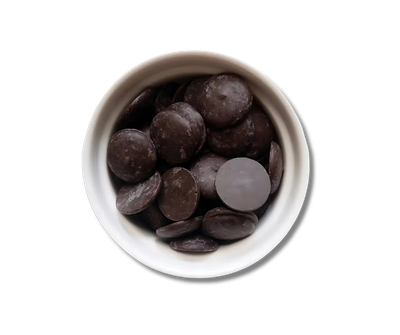 A white bowl filled with raw chocolate chips on a white background