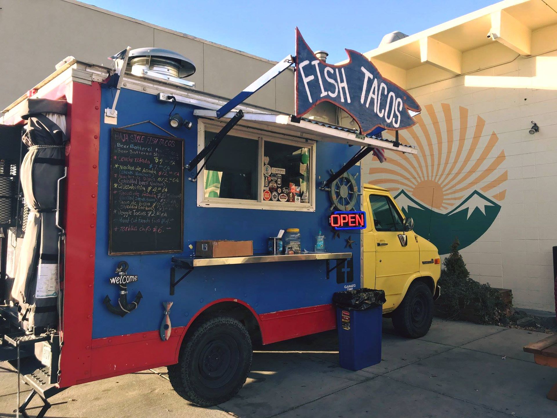 a fish tacos truck is parked in front of a building