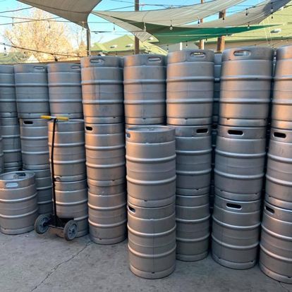 A bunch of kegs are stacked on top of each other.