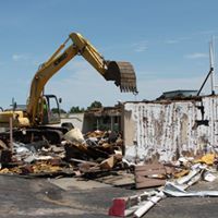 Backhoe destroying building