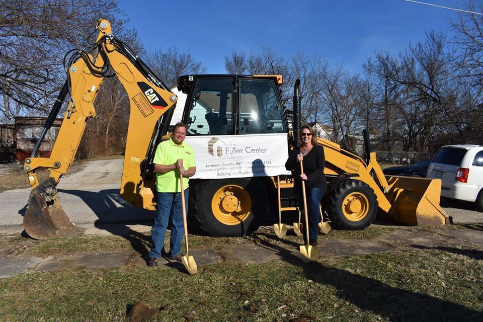 Richter Owners holding giants check in front of backhoe