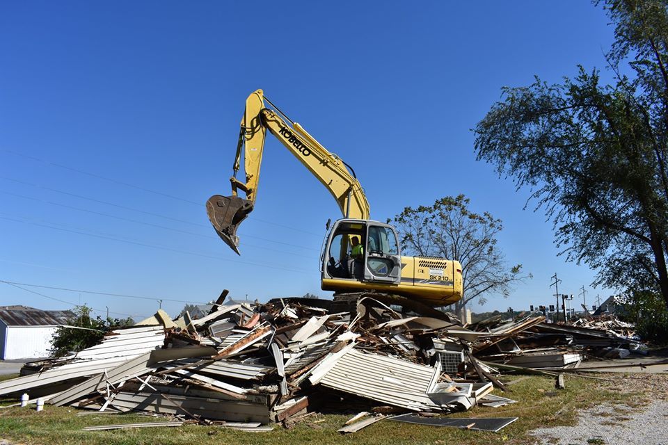 Backhoe demolishing old building