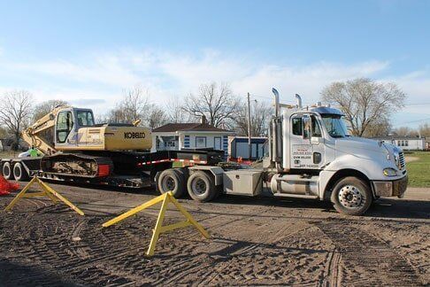 Excavator on semi truck trailer