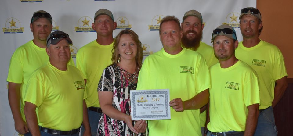 Richter employees holding an award