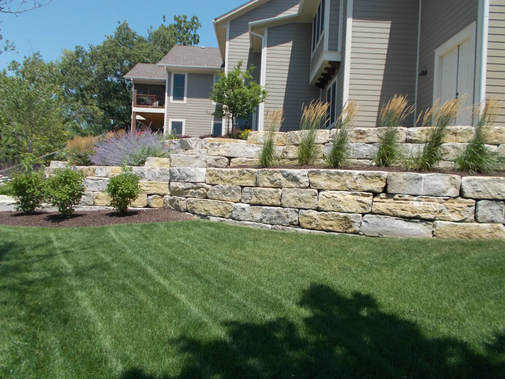 A house with a stone wall in front of it