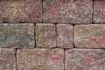 A close up of a stone wall with bricks of different colors.