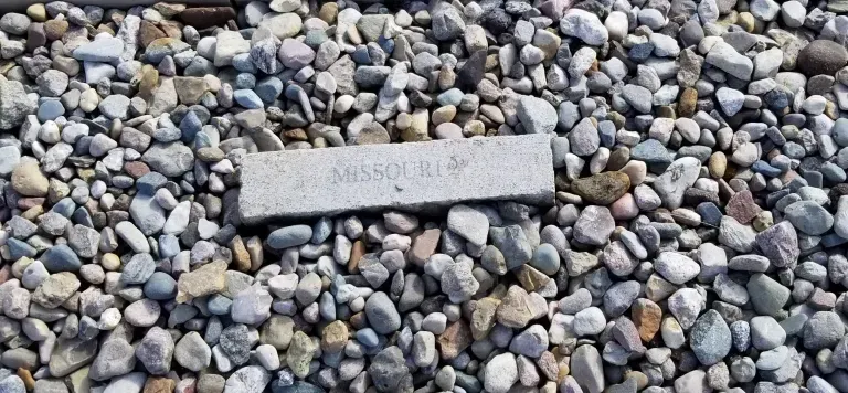 A gravestone is sitting on top of a pile of gravel.