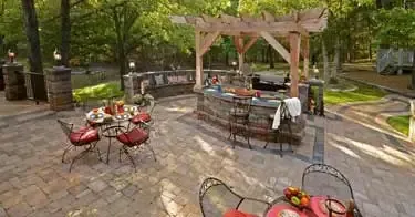 A patio with tables and chairs and a pergola.