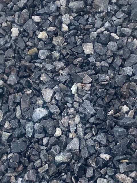 A gravestone is sitting on top of a pile of gravel.