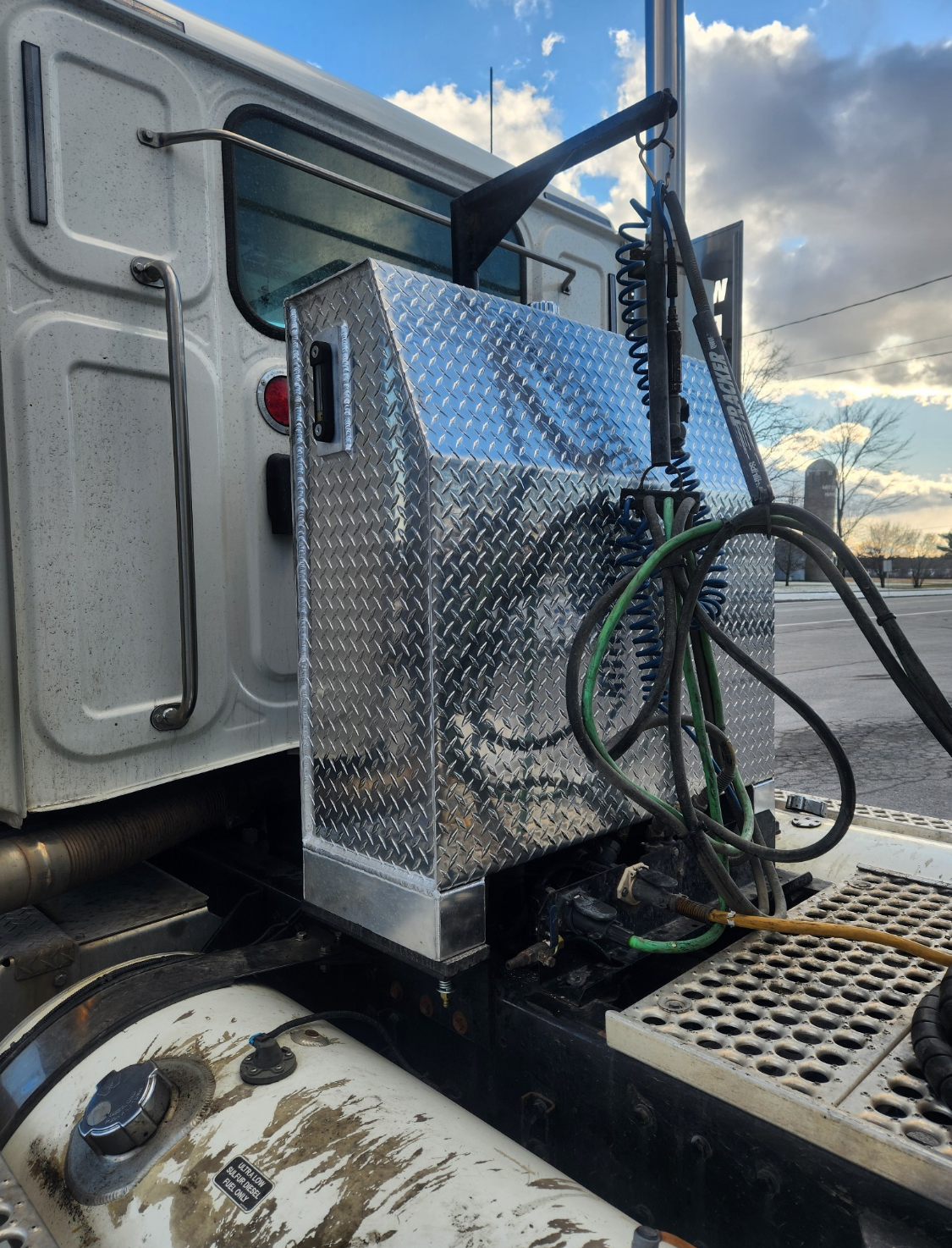 Boîte à outils plaquée diamant montée sur un semi-remorque à côté de la cabine.