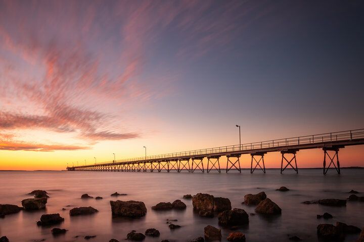 A pier overlooking a body of water at sunset