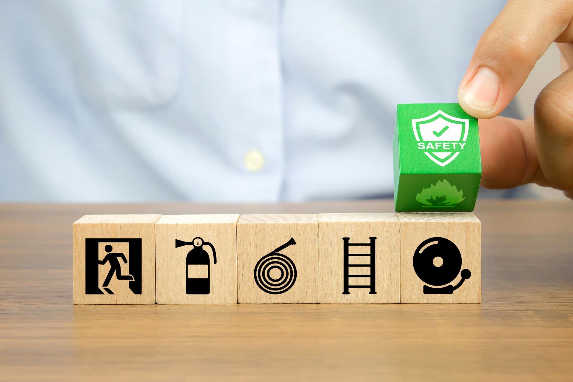 A person is holding a green cube that says safety on it.