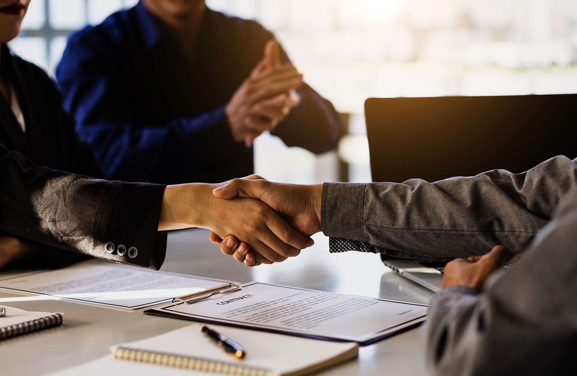 A group of people are shaking hands over a table.