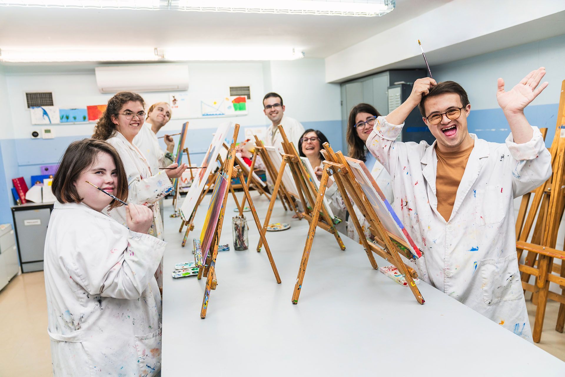 A group of people are standing around a table with easels.