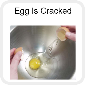 A person cracking an egg into a bowl with the caption egg is cracked