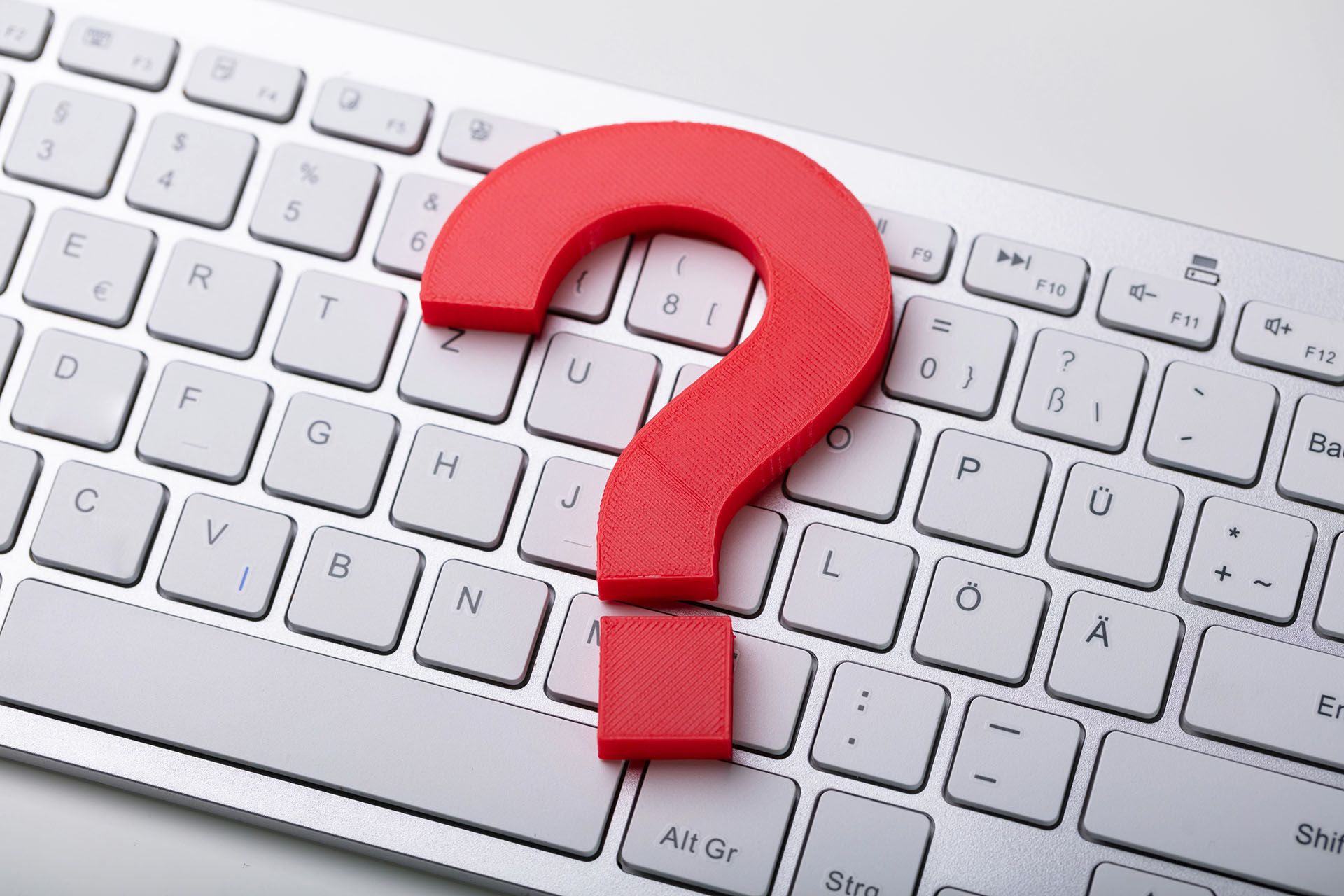 A red question mark is sitting on top of a white keyboard